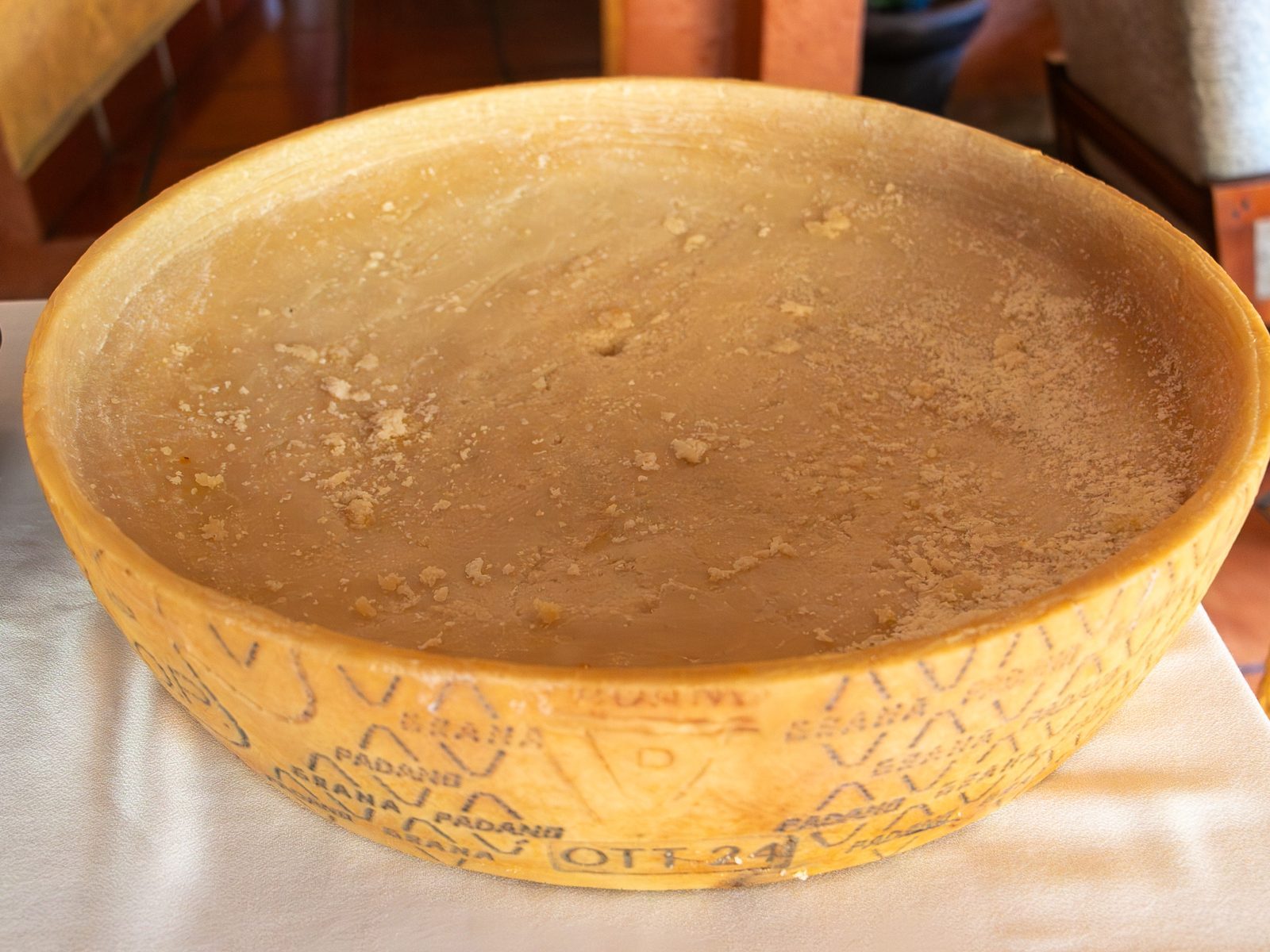 Rueda entera de Grana Padano ahuecada desde arriba, con el sello de la denominación visible en el costado